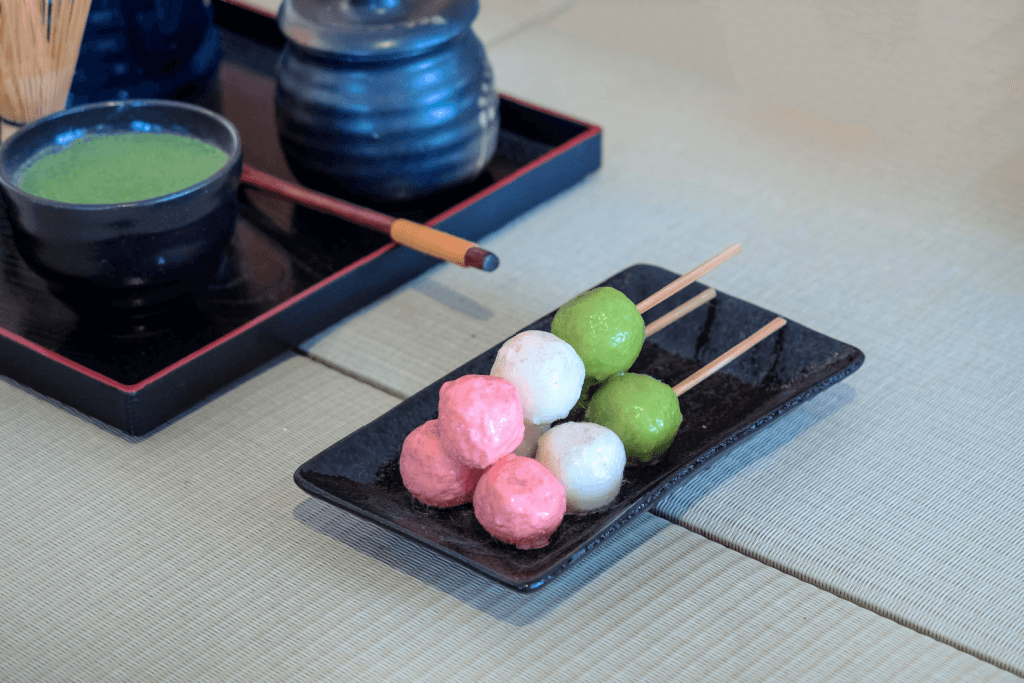 A plate of hanami dango on a tatami mat.