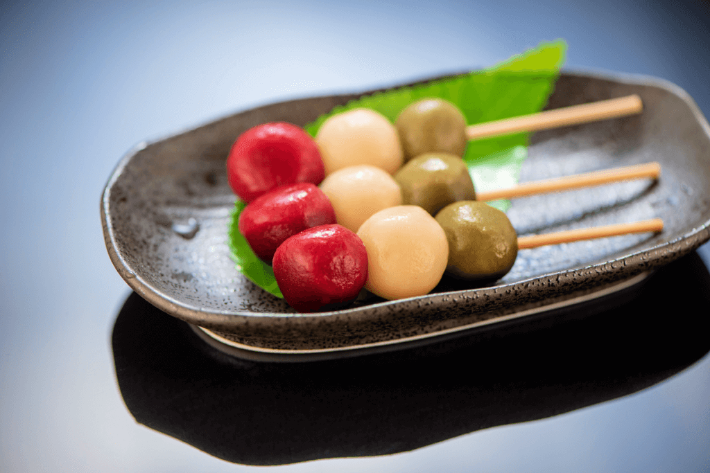 A plate of hanami dango that has very red dumplings.