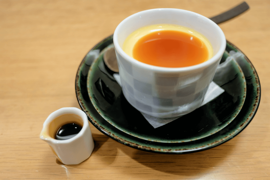 A dish of sweet Japanese pudding for with caramel syrup on the side.