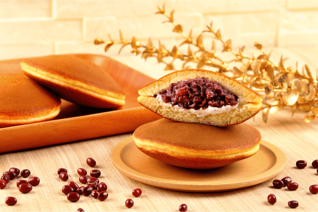 A plate of dorayaki with red bean paste and custard, with sheaths of wheat and raw red beans around it.