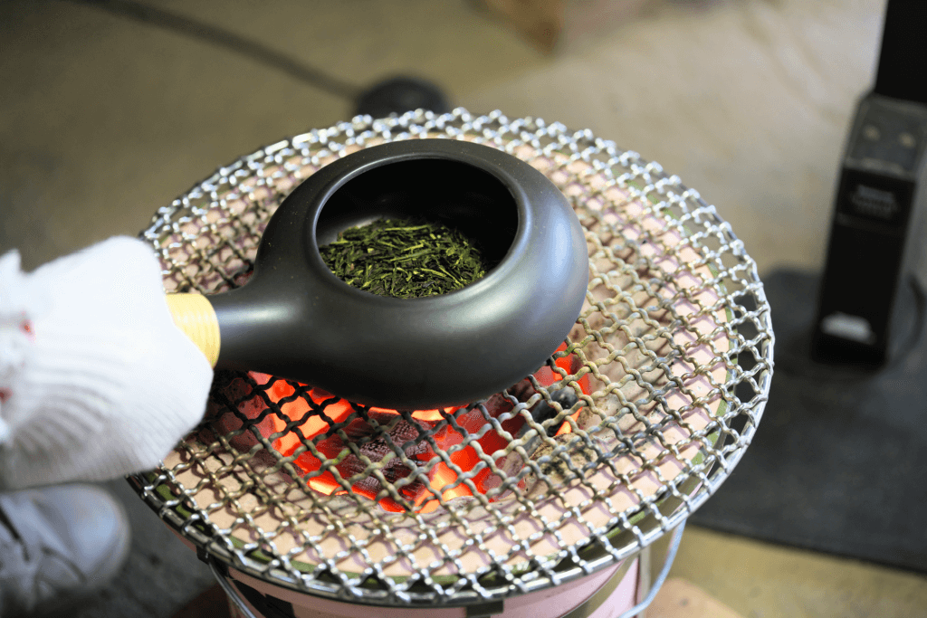 Roasting green tea leaves in an earthenware pot.