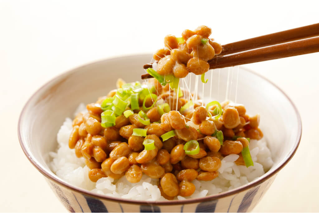 A bowl of rice topped with natto and chives.