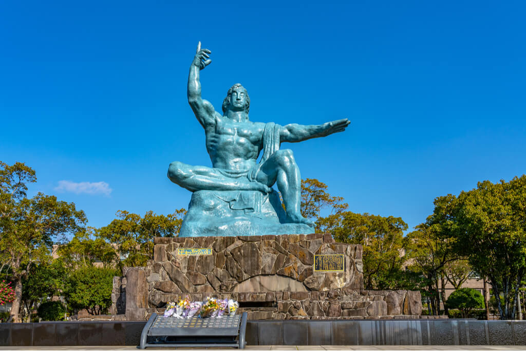 The peace statue of a man sitting on a rock at the Nagasaki Atomic Bomb Park, a Kyushu culture site.