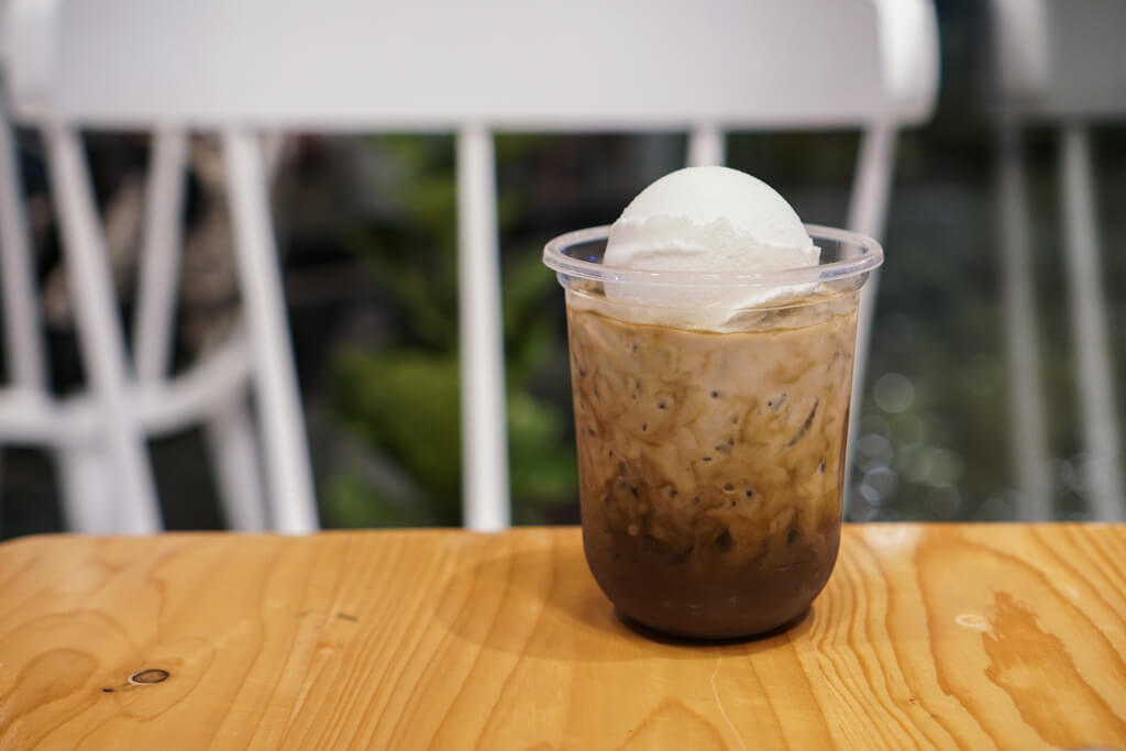 A cup of iced tea with a scoop of ice cream made of Hokkaido milk on top of it.
