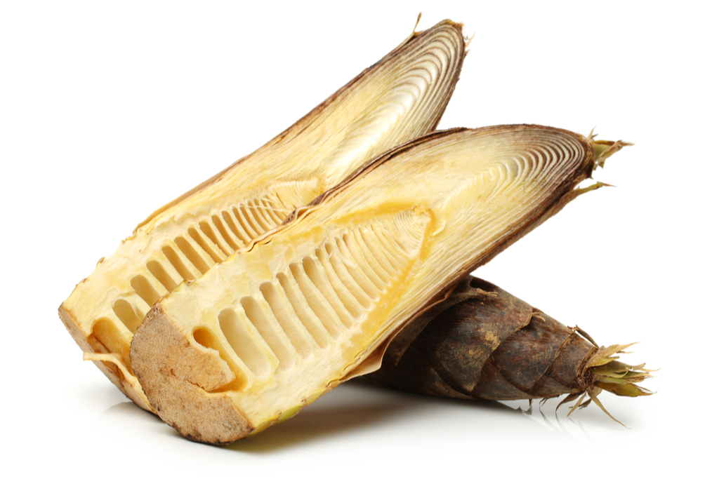 A photograph of a split-open bamboo shoots.  It has a lot of cavities on the inside, like the inside of a piano.
