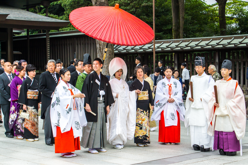 A Japanese wedding ceremony held at a Shinto shrine with the couple and the priests dressed in traditional Japanese garb.