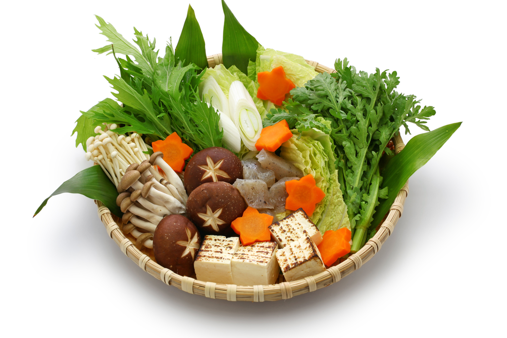 A straw basket consisting of raw ingredients for nabe, mainly tofu, onions, mushrooms, konjac and sakura shaped carrots.