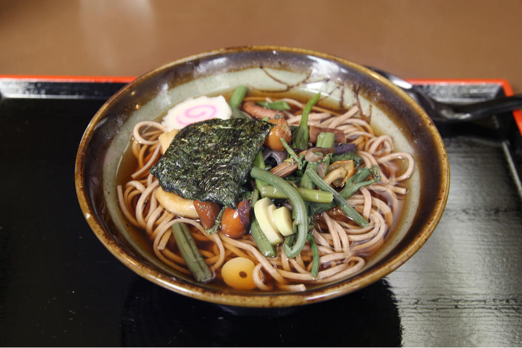 Sansai soba, one of the popular cold soba dishes, with many different vegetables like mushrooms and bamboo over the noodles and soup.