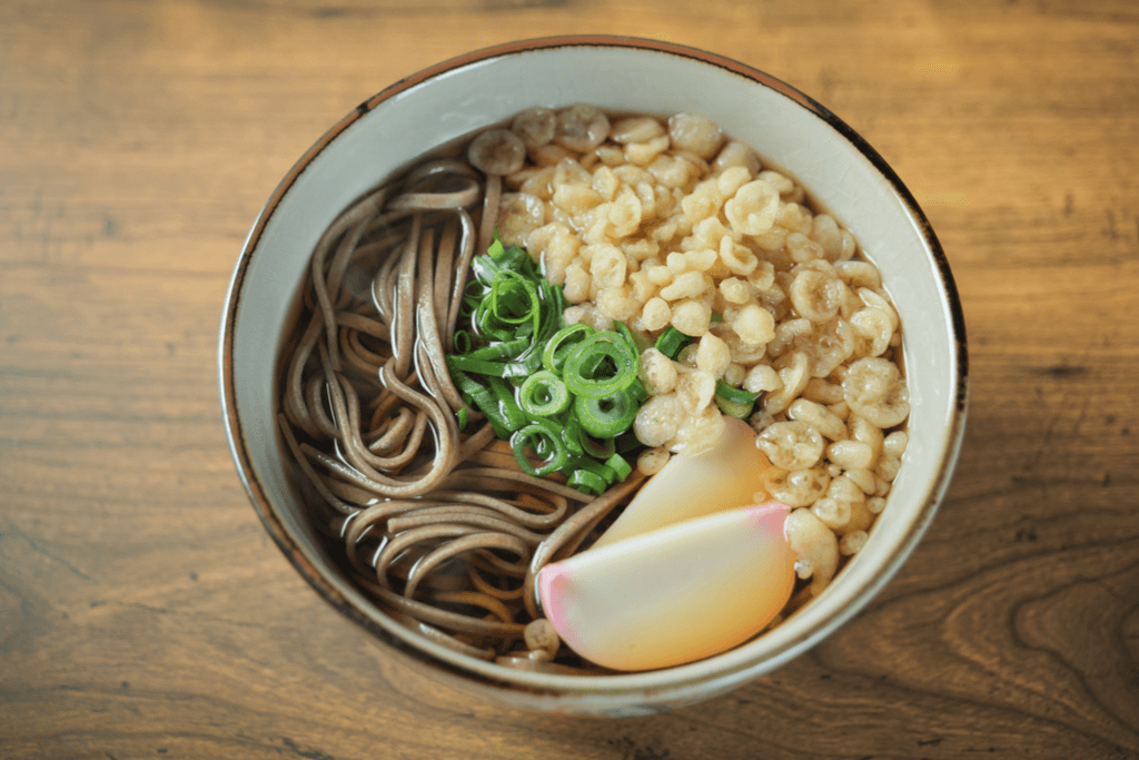 A bowl of hot tanuki soba, called so because of the golden tempura fried bits decorating half of the dish with the other half having green onions and fish cakes on top. 