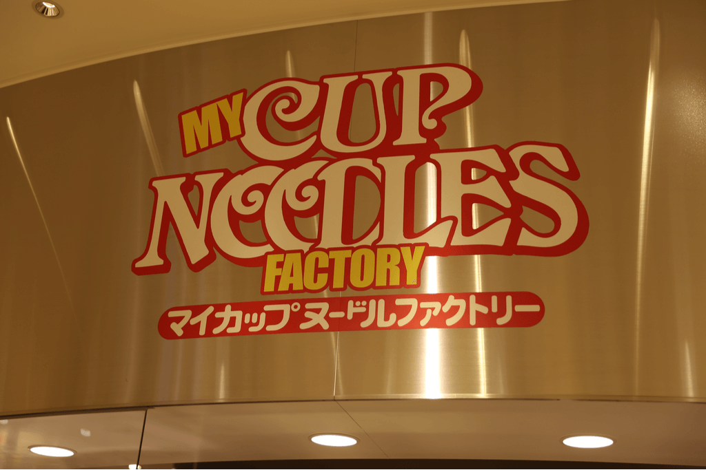 The My Cup Noodles Factory sign at the Yokohama Cup Noodle Museum, one of the other Yokohama museums about ramen, hangs above the area's entrance.