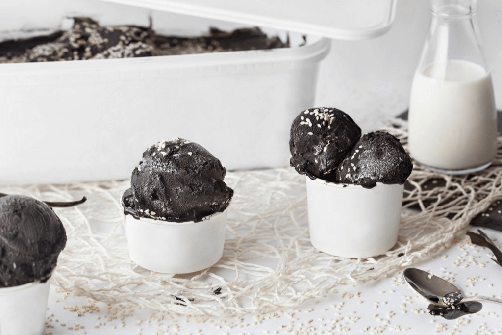 An image of black sesame gelato in white cups.