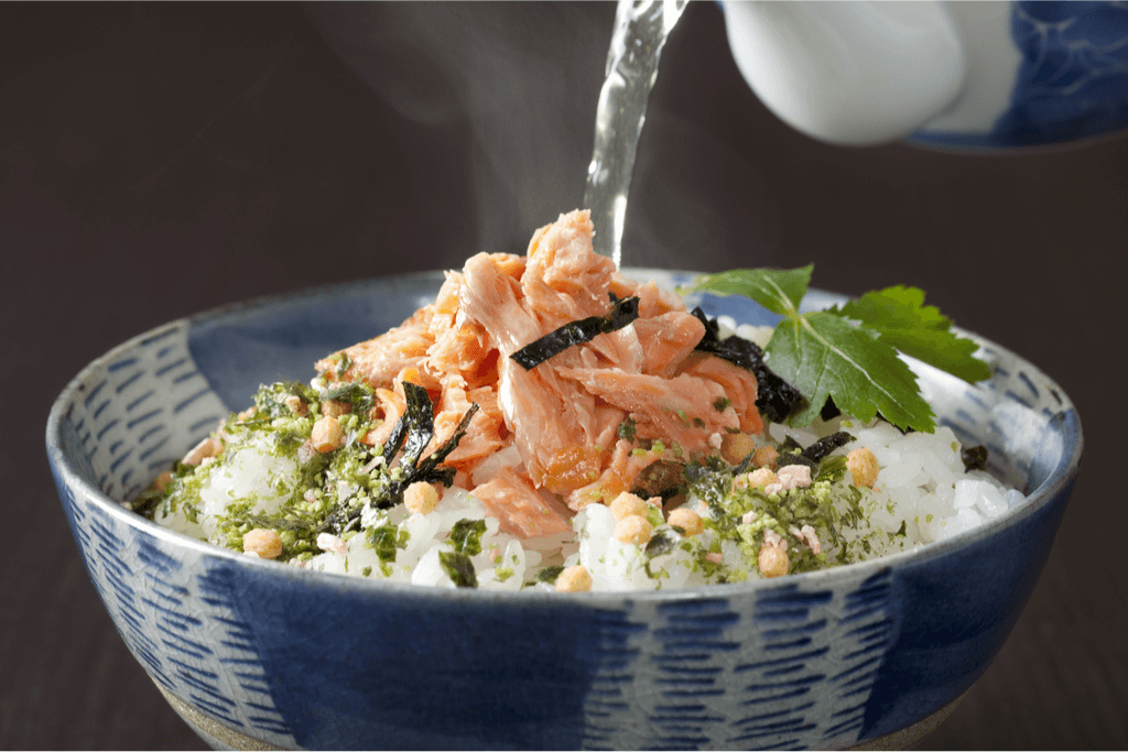 Green tea poured over a bowl of rice and salmon, making chazuke, an underrated Japanese dish.