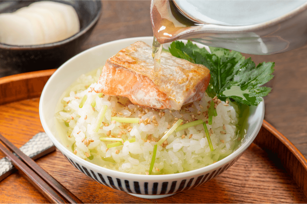 A bowl of salmon chazuke--green tea rice soup topped with grilled salmon and shiso leaf.