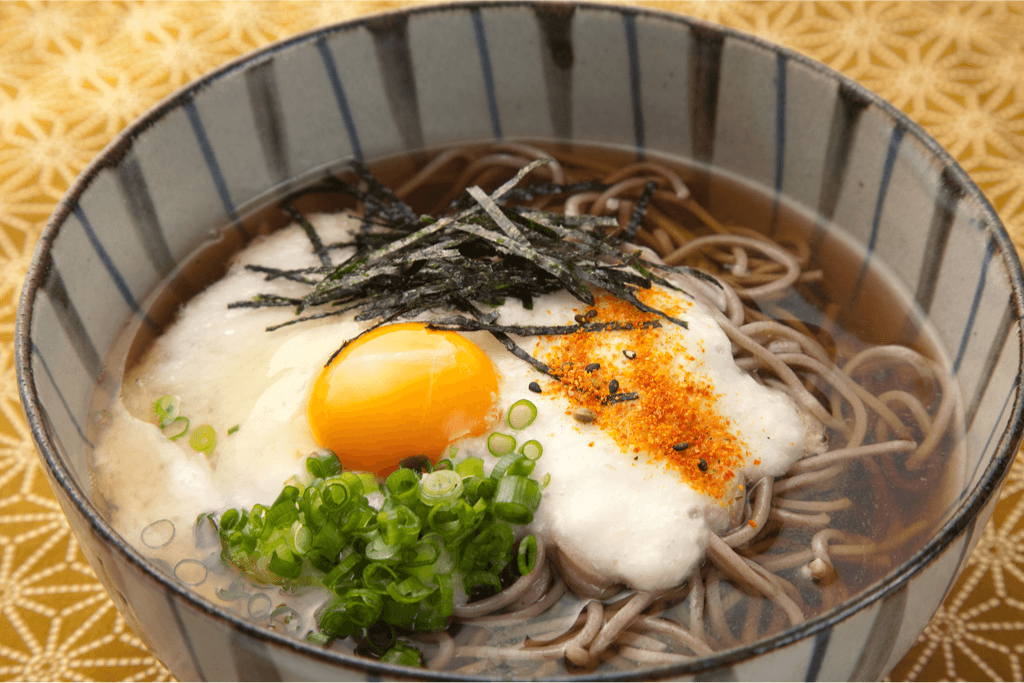 A bowl of seasoned tsukimi soba which is buckwheat noodles with egg on top, usually eaten to celebrate the moon-viewing season.