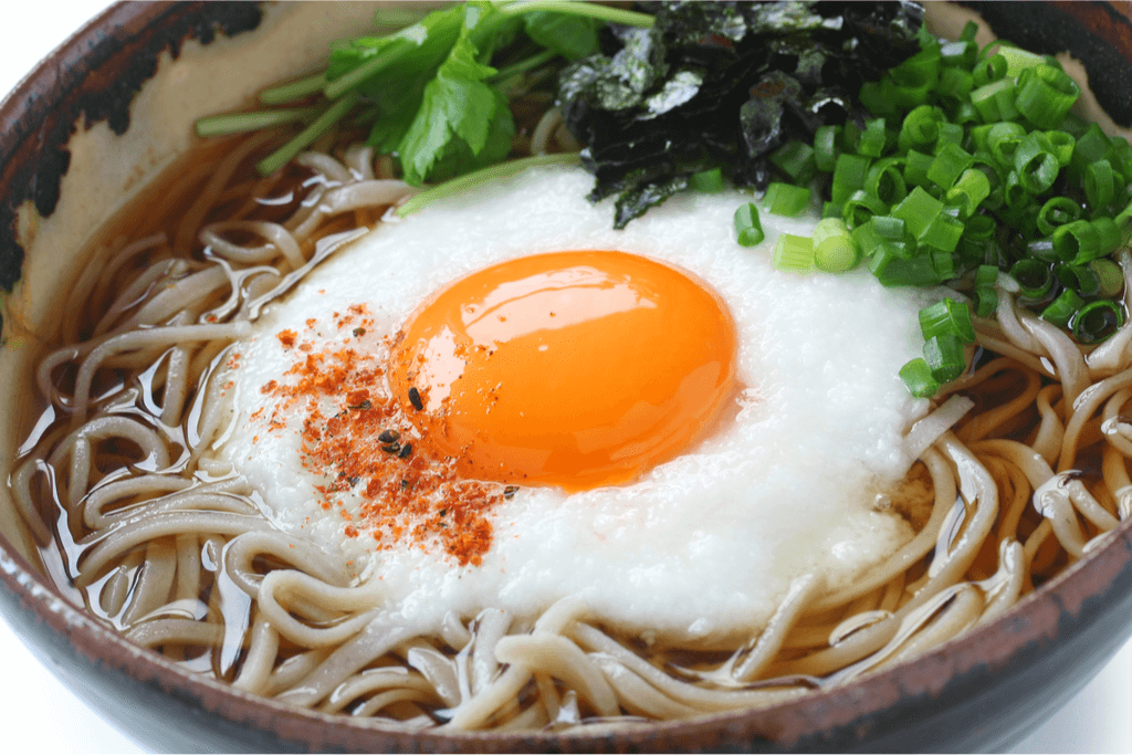 A bowl of the traditional tsukimi food which is hot soba with an egg on top. It's one of many traditional tsukimi foods. 