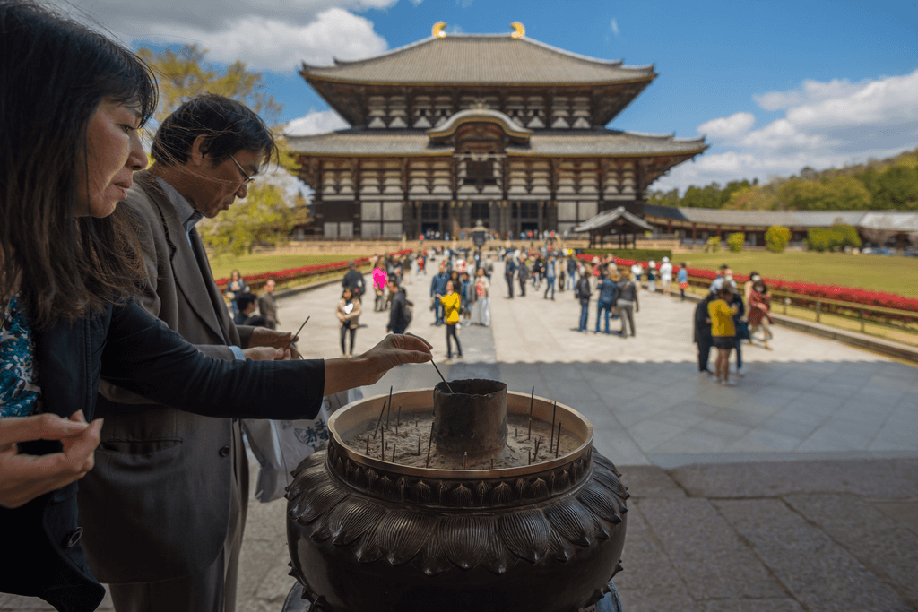A visitor lighting an incense sticks for praying at Todaiji Zen Buddhism, temple, Nara Japan 