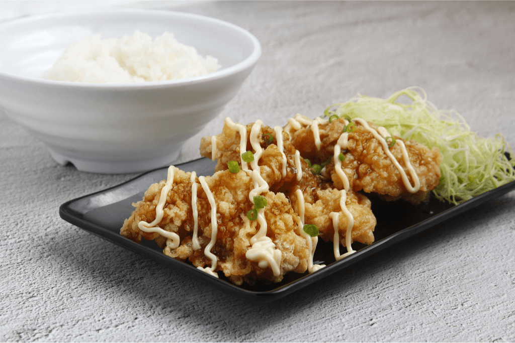 A plate of karaage, with mayonnaise drizzled on top.