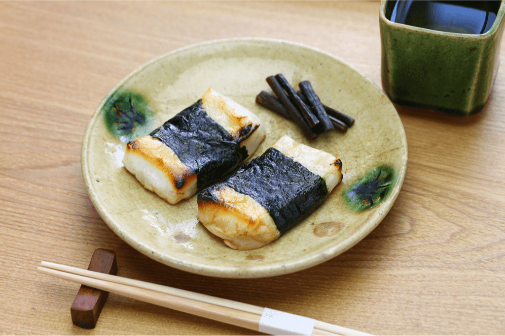 A plate of roasted kirimochi wrapped in seaweed.