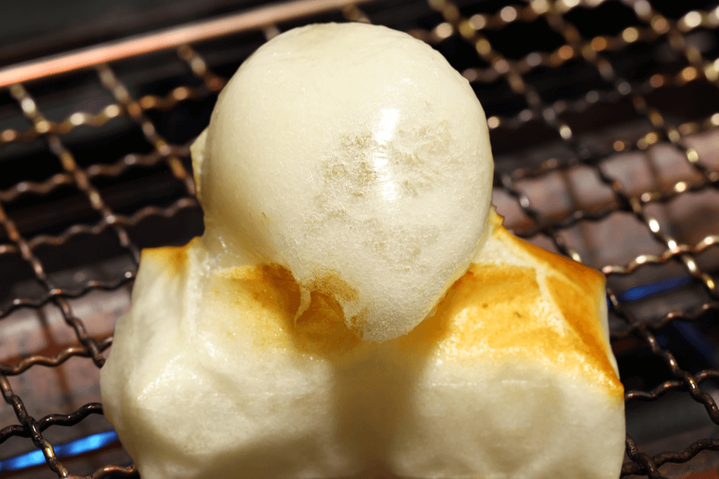 A delicious slice of kirimochi toasting and bubbling in the oven.
