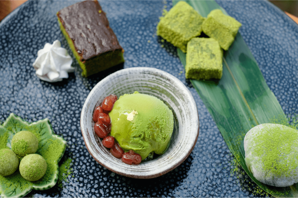 A photograph of different kinds of matcha green tea flavored desserts, including chocolate, ice cream and cake.
