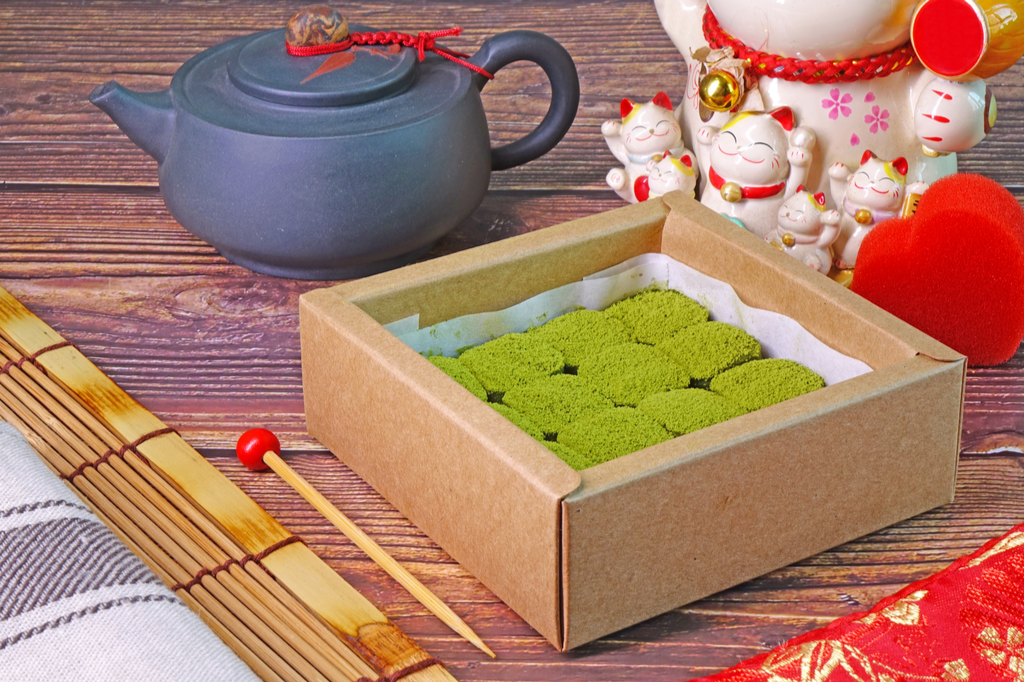 A box of matcha (read: green tea) chocolates, with a lucky porcelan cat and a tradiitonal Japanese teapot.