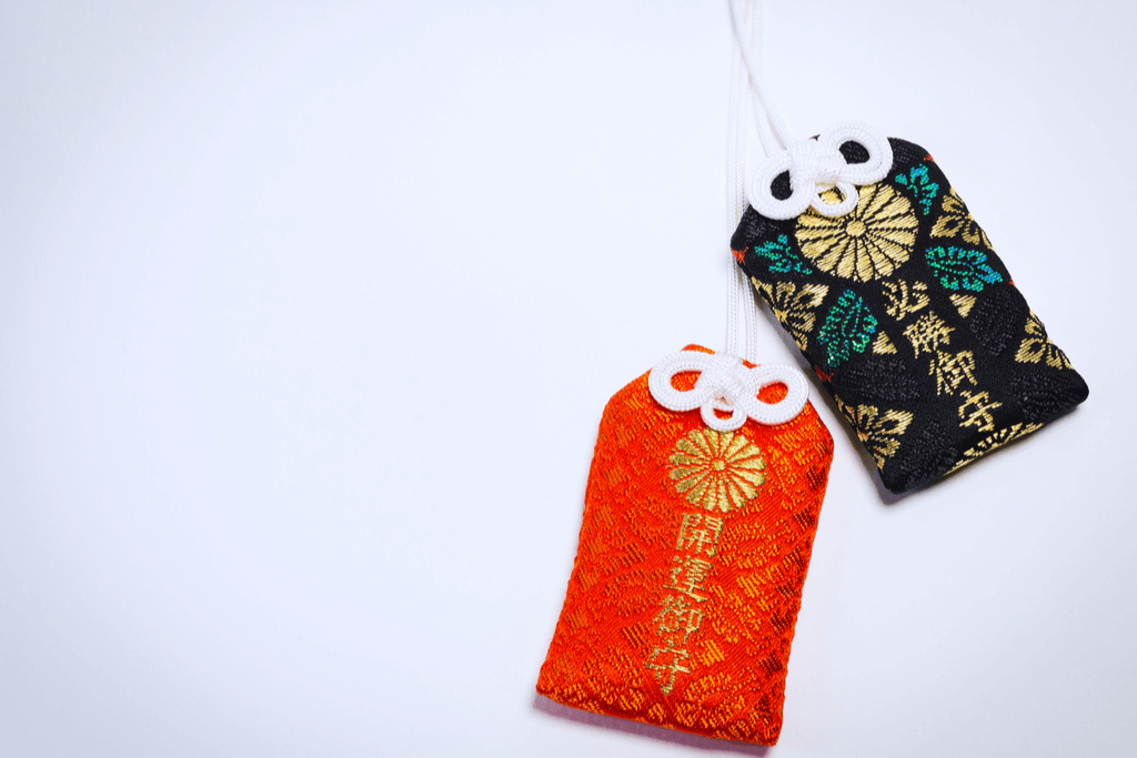 A red and dark green omamori good luck charm from Japan.