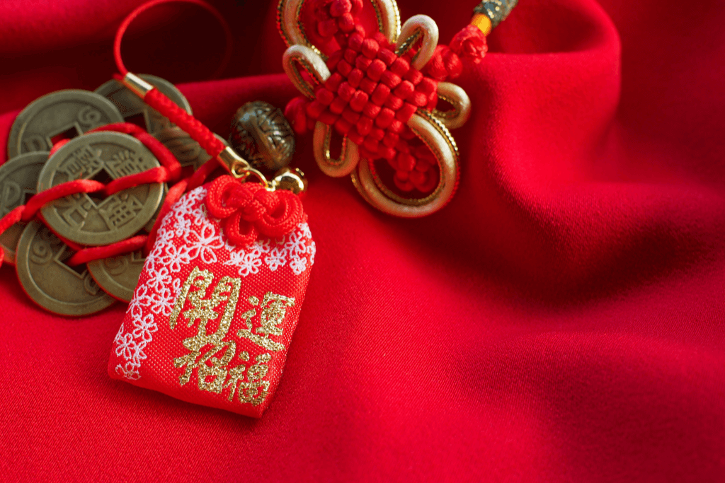 A red kai-un omamori charm against a red satin background.