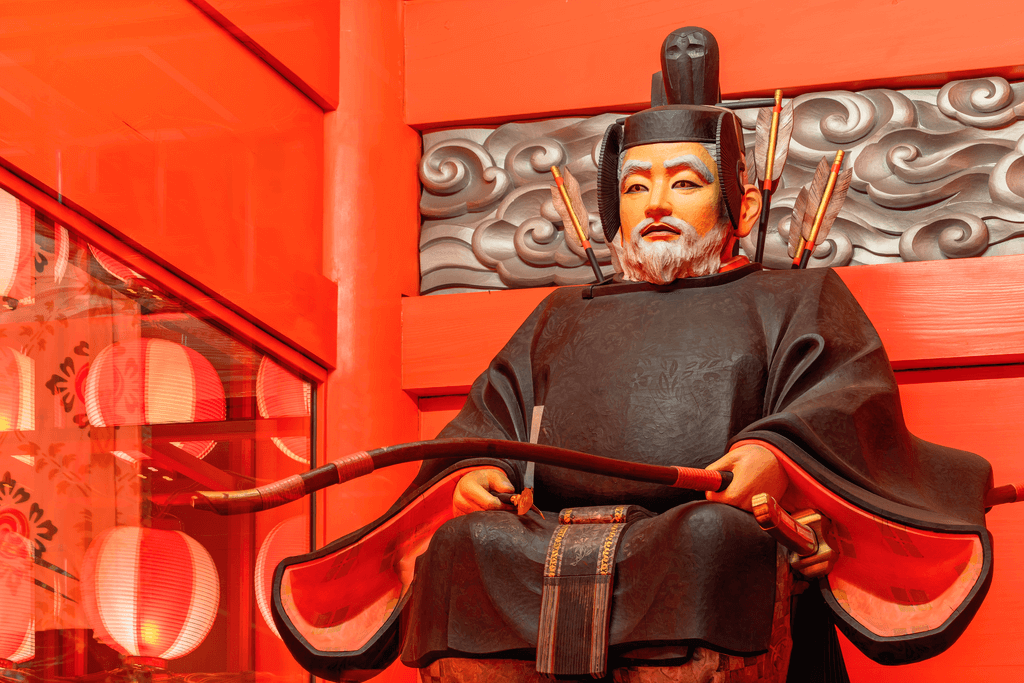 An orange statue of a god from the Shinto religion.