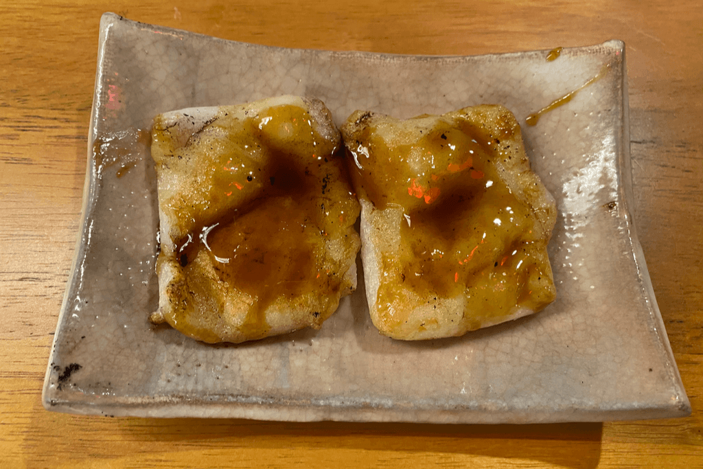 A plate of kirimochi smeared with sweet soy sauce.