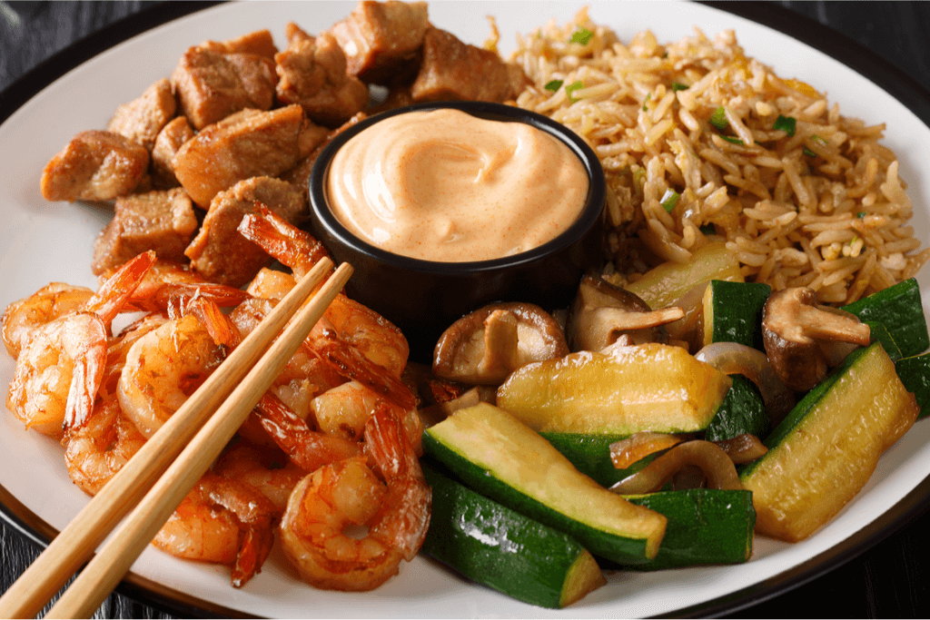 A teppanyaki plate of fried rice, shrimp and vegatables.