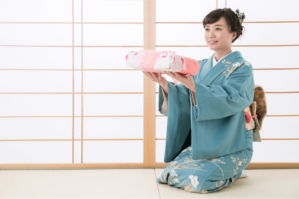 Woman wearing a kimono offering a gift