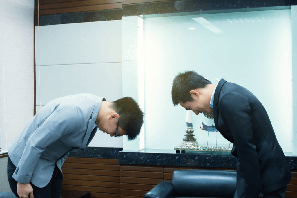 Two Asian men bowing to each other