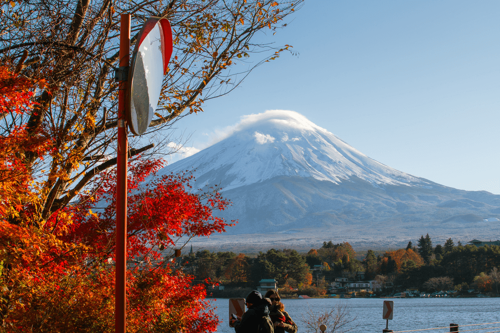 Mt Fuji one of the mythical mountains of Japan, among some red autumn foliage.