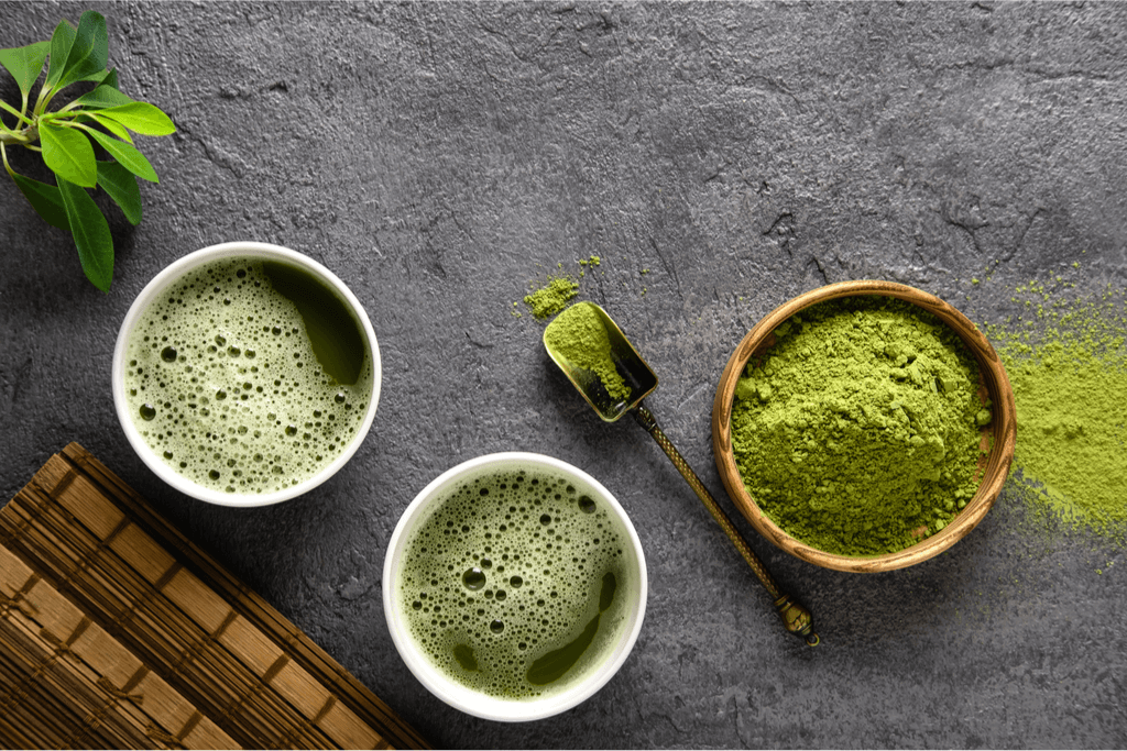 Uji matcha latte, tea and powder against a gray background.