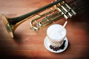 A trumpet and a milkshake on a table at a Yokohama jazz cafe.