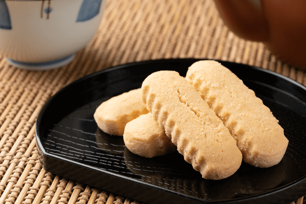 A plate of beige chinsuko (shortbread) cookies with jagged edges.