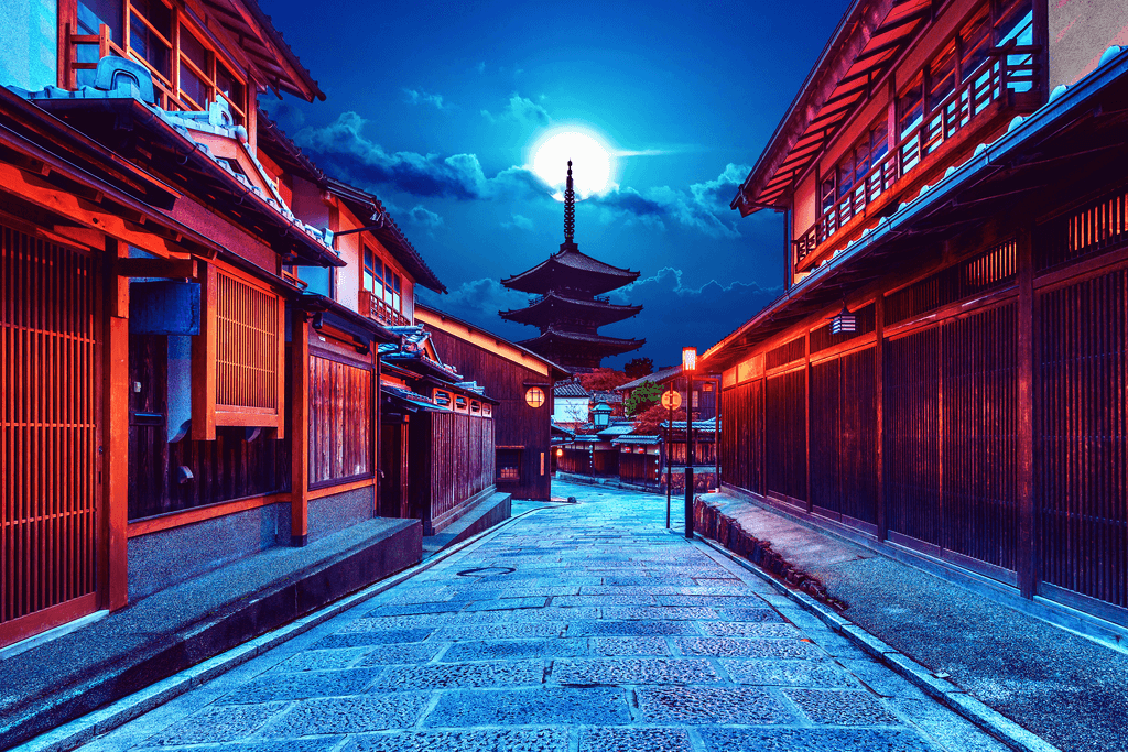 A nighttime scene of Kyoto during the Kyoto Moon Festival. The moon is bright the sky is dark blue, and the machiya townhouses are red.