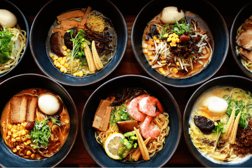 Rows and rows of bowls of ramen, a traditional Japanese food. It features met, eggs, tofu, seaweed and noodles.