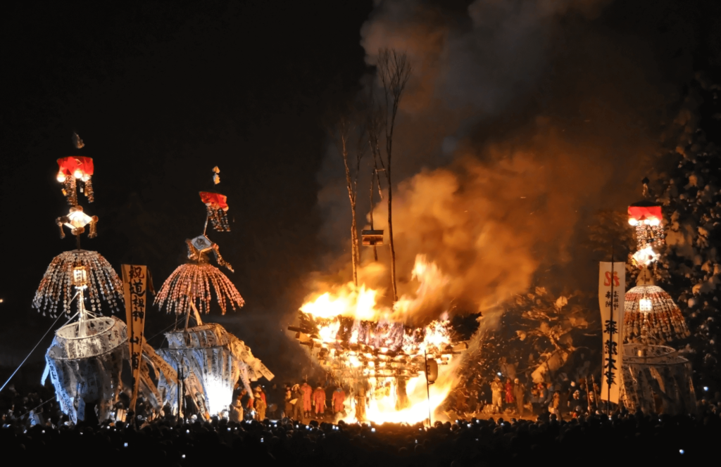 Two towers on either side of a shrine on fire at the Nozawa Fire Festival. This is a very famous winter festival.