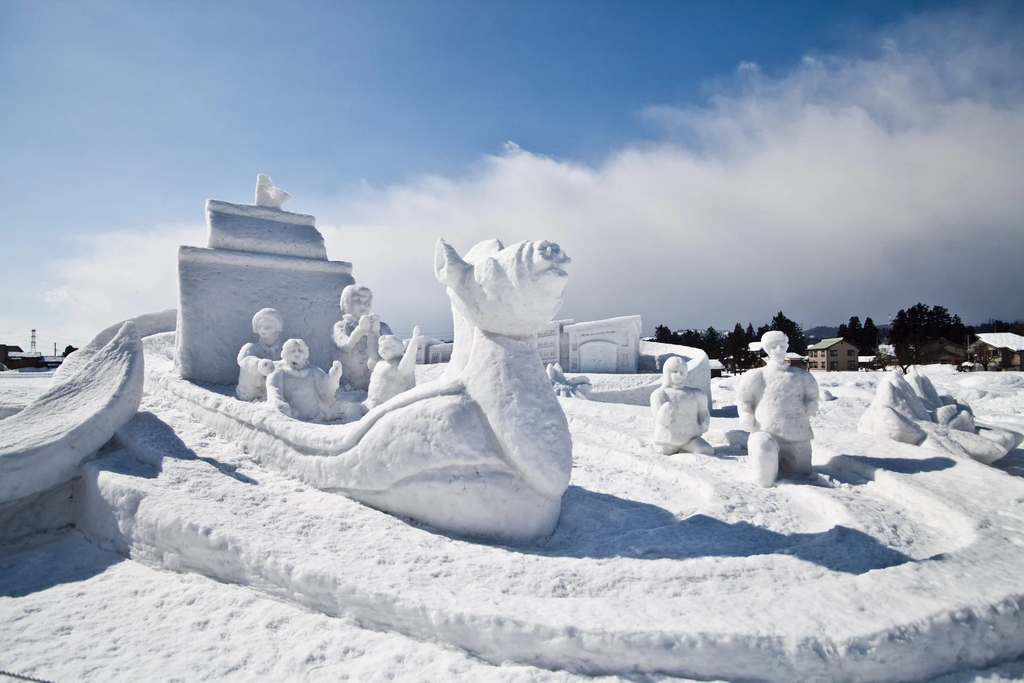 A picture of a dragon snow sculpture in the daytime.