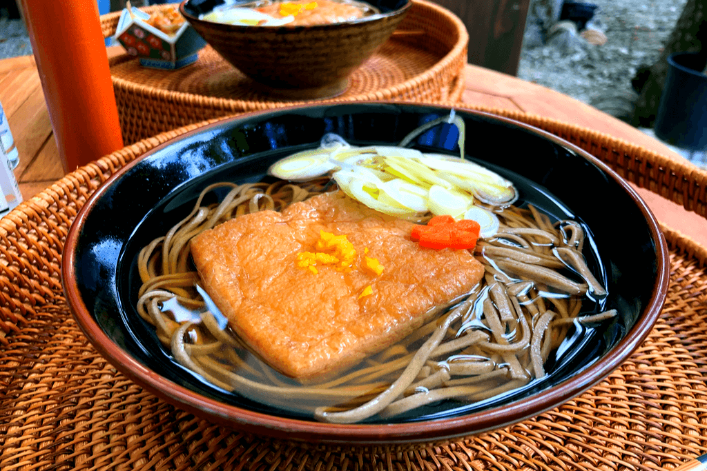 A bowl of toshikoshi soba with fried tofu on top.