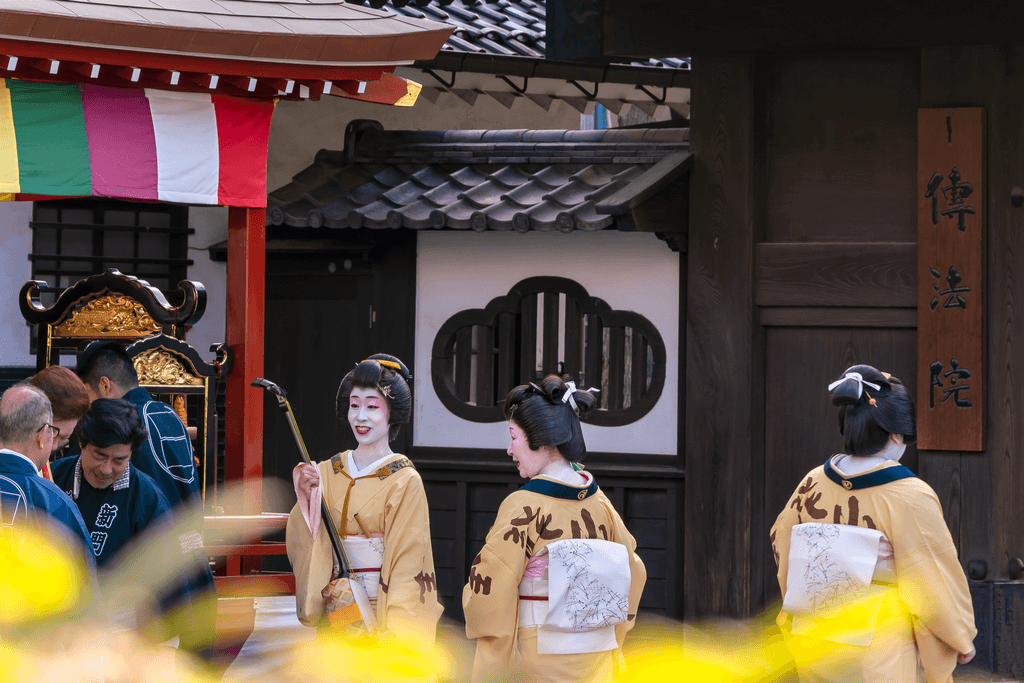 A picture of three women dressed in yellow playing shamisen during a traditional Japanese Tokyo lifestyle festival in Denbouin.