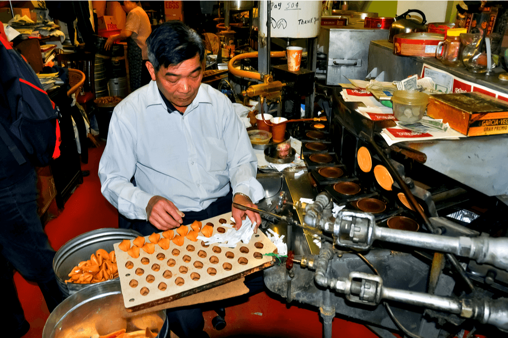 A man is making a curved pastry at a factory.