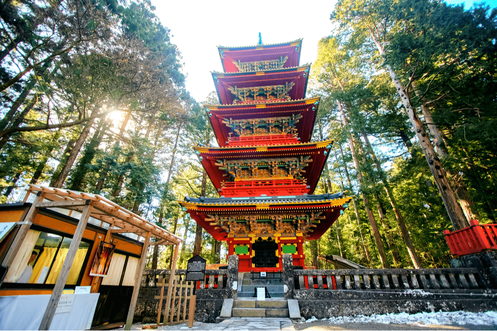 A tall, red and gold pagoda in Tochigi, a nature wonder.