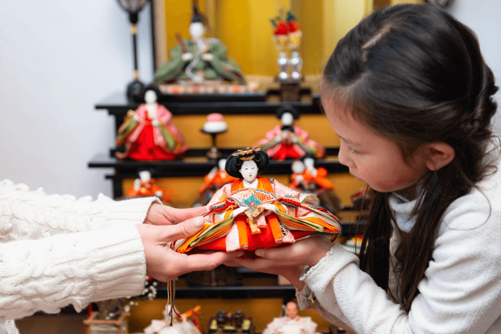 A mother presents an empress doll to her daughter on Girls Day.