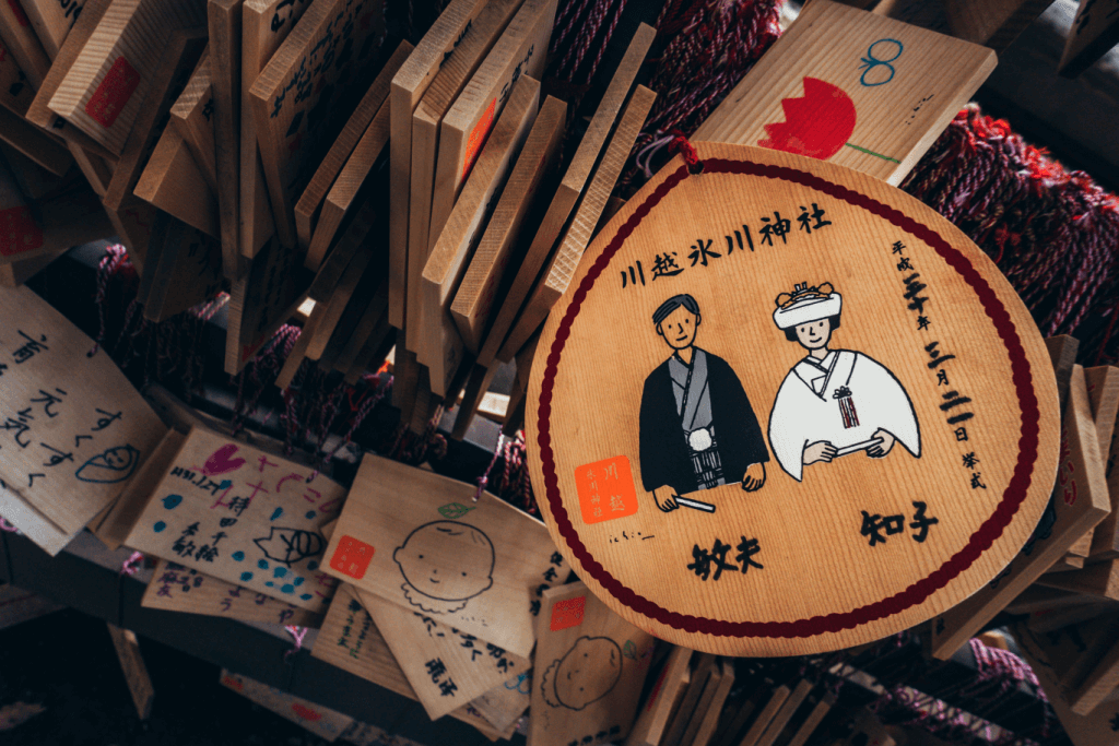 An ema woodboard at Hikawa Shrine depicting a bride and groom.