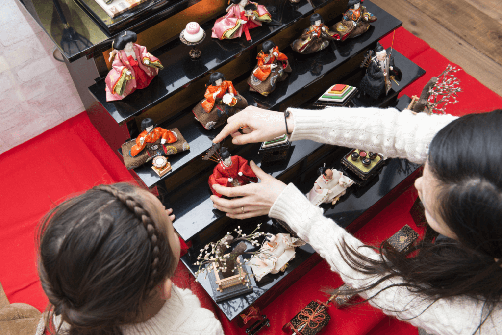 A mother and daughter decorating a hina doll set for Girls Day.