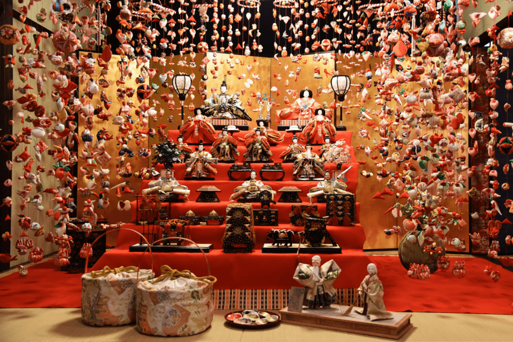 An elaborate display of hina dolls among flower decorations.
