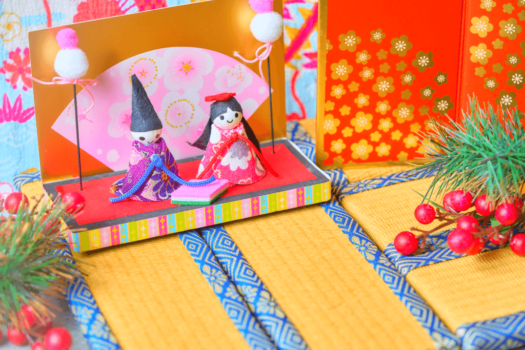 A [air of hina dolls on a tatami mat. They are loosely related to the peach blossom.