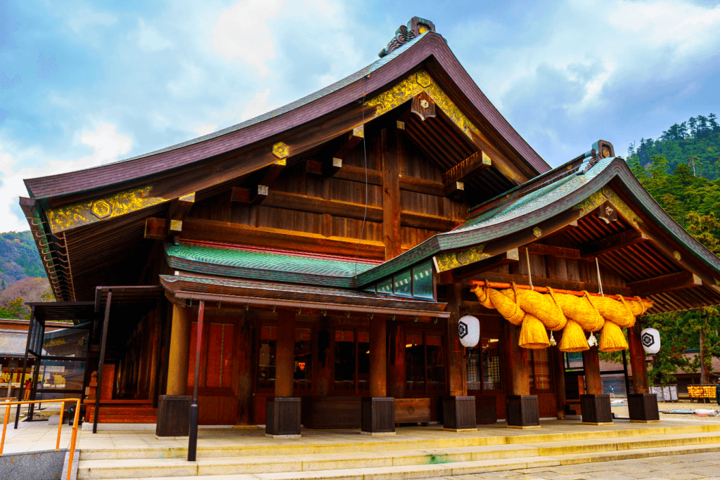 Exterior of Izumo Taisha Shrine. It's wooden with yellow paint.
